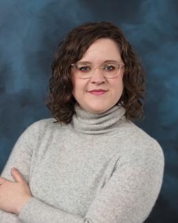A woman with shoulder-length hair and glasses.