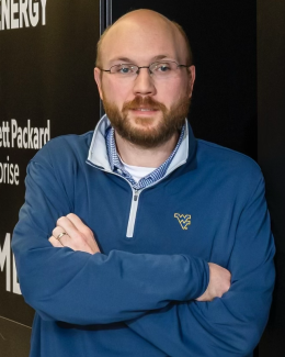 Photo of Bald Man in Blue Shirt with Flying WV Logo