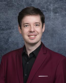 Michael Sebok wearing a black dress shirt with maroon jacket