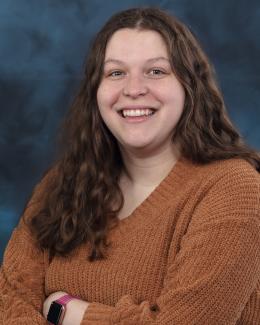 Photo of Emma Reid smiling with arms crossed