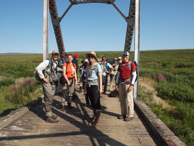 Multi-institutional group of climate researchers standing on a bridge about to set out for field work.