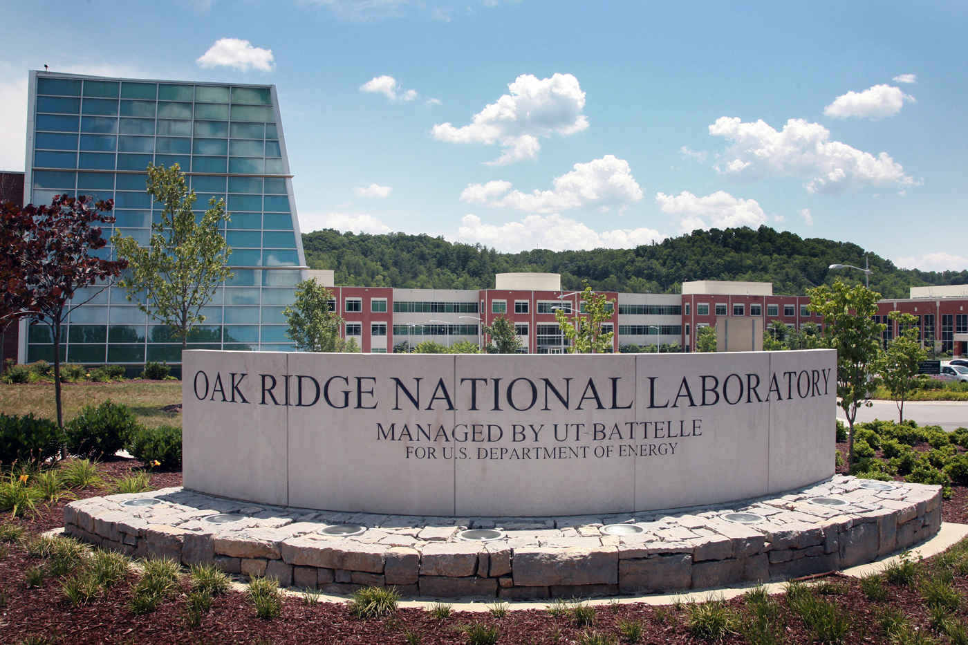 Entrance sign for Oak Ridge National Laboratory in Tennessee, with the words “Oak Ridge National Laboratory” engraved on a curved stone sign in the foreground
