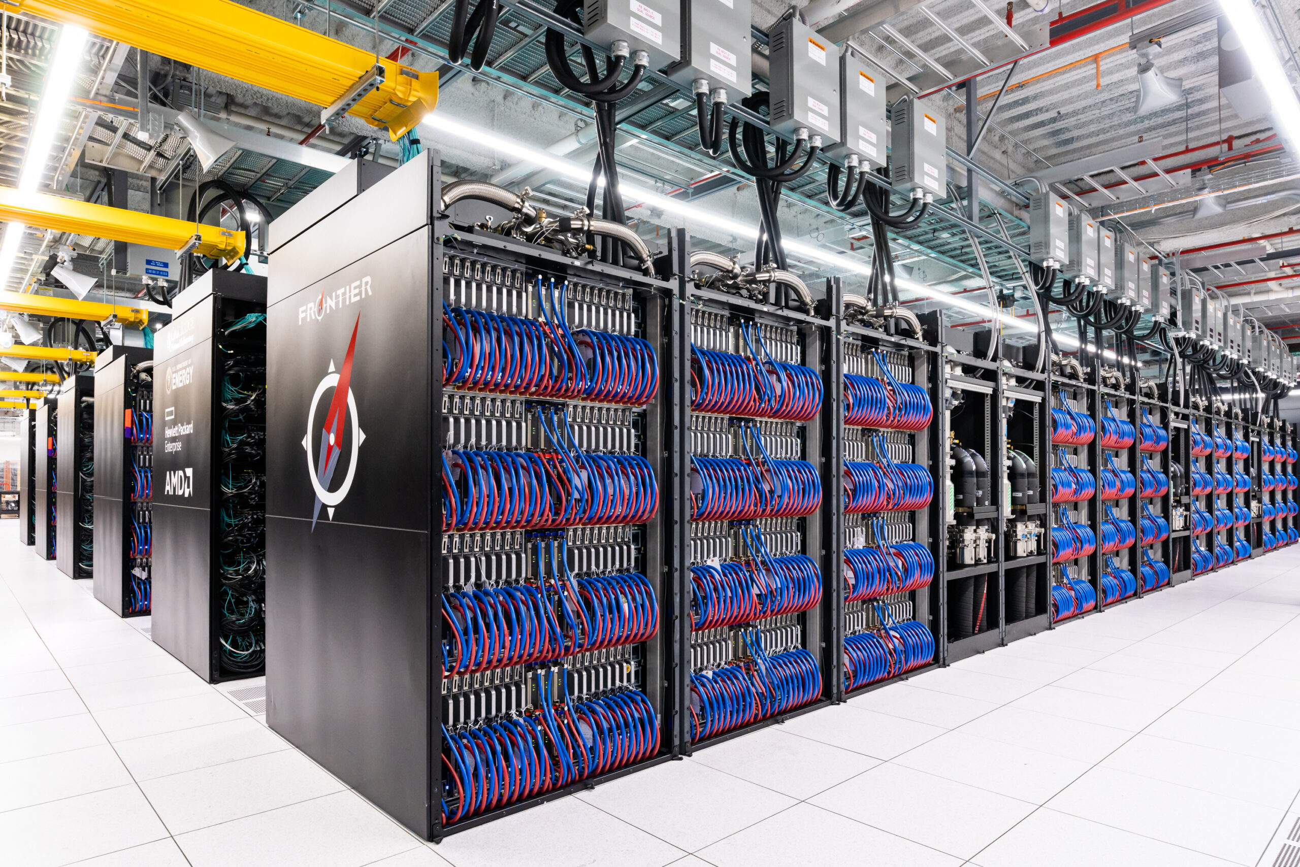 Frontier supercomputer with open cabinets showing cooling cables