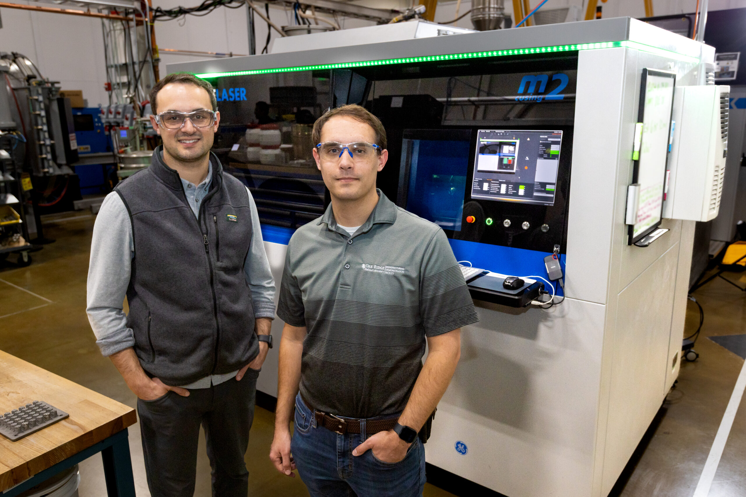 Luke Scime and Zackary Snow work with the Peregrine software tool to monitor and analyze a component being 3D printed at the Manufacturing Demonstration Facility. Credit: Genevieve Martin/ORNL, U.S. Dept. of Energy