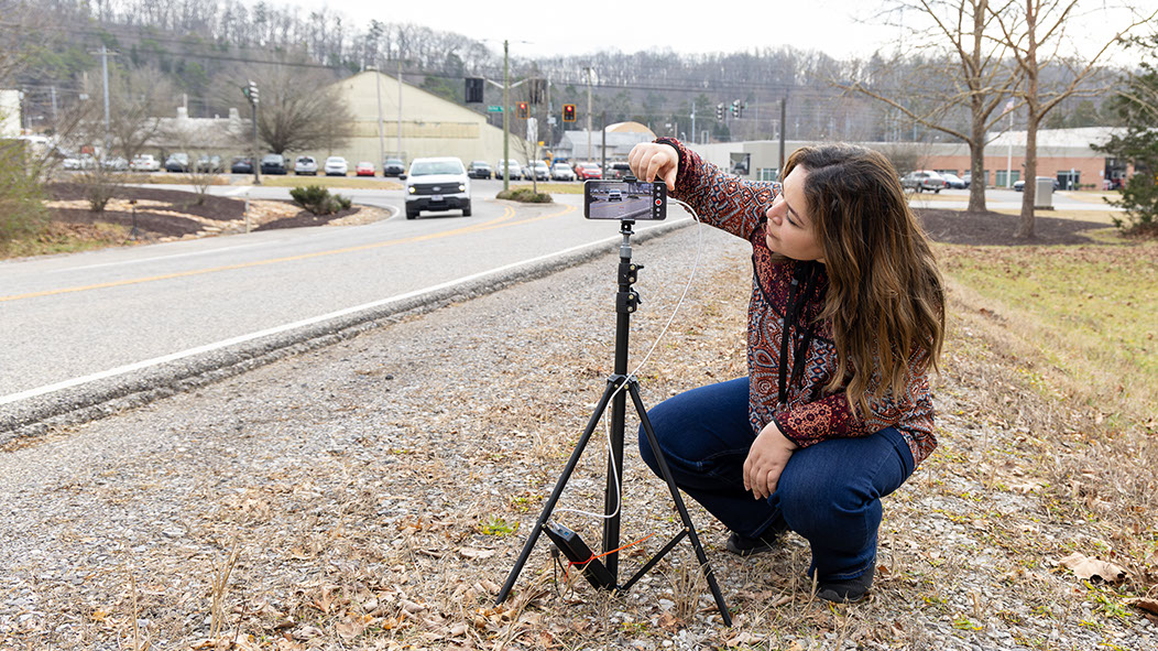 Researcher Sally Ghanem sets up a camera to capture license plate numbers of passing vehicles at an ORNL intersection to match vehicles with drone video recordings