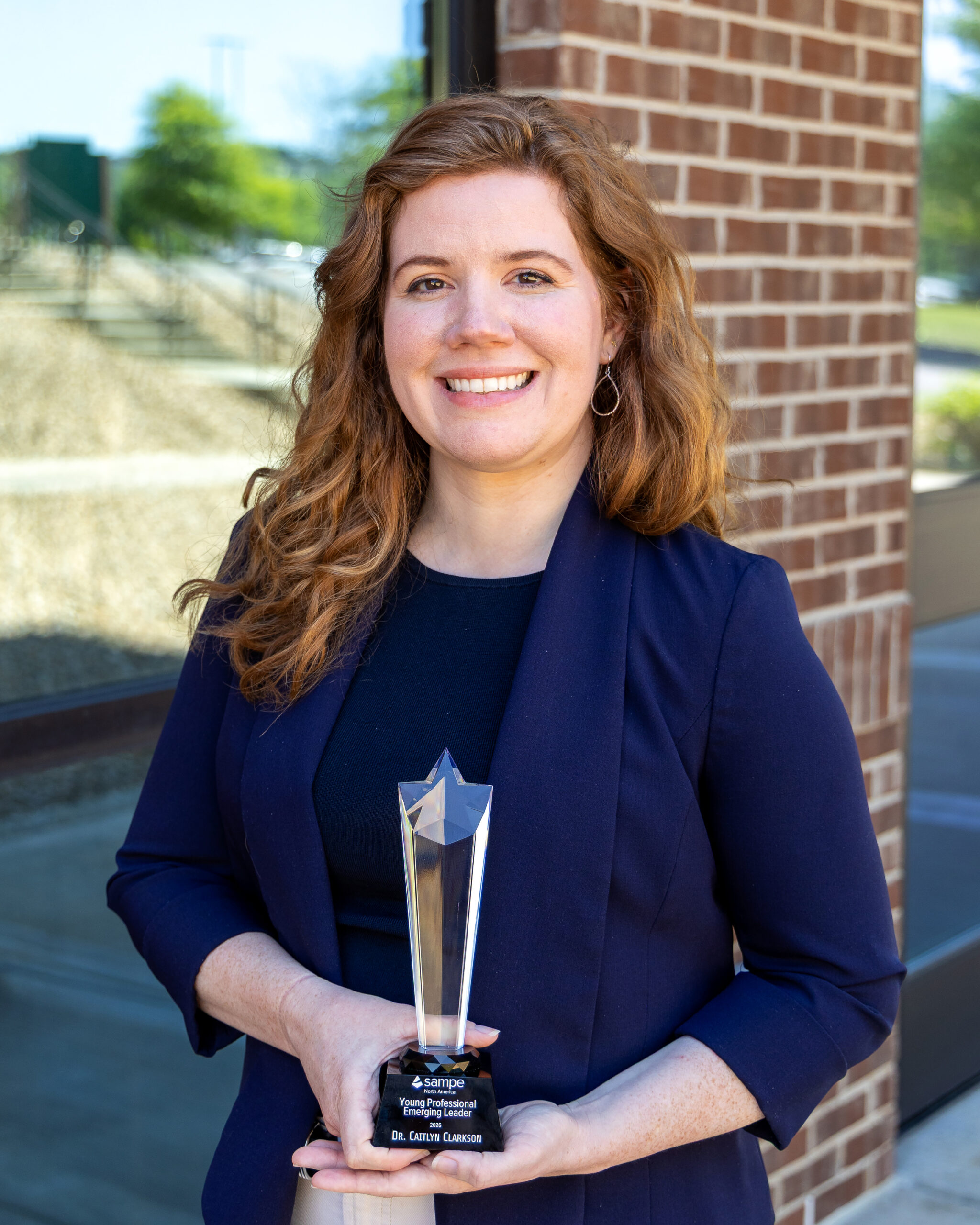 Photo of Cait Clarkson holding her award