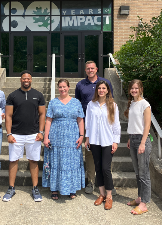 group of people pose in front of stairs at Oak Ridge National Laboratory