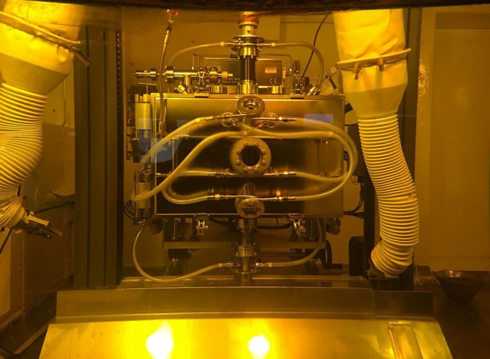 An image with a yellow hue shows a boxy piece of equipment with wires and tubing