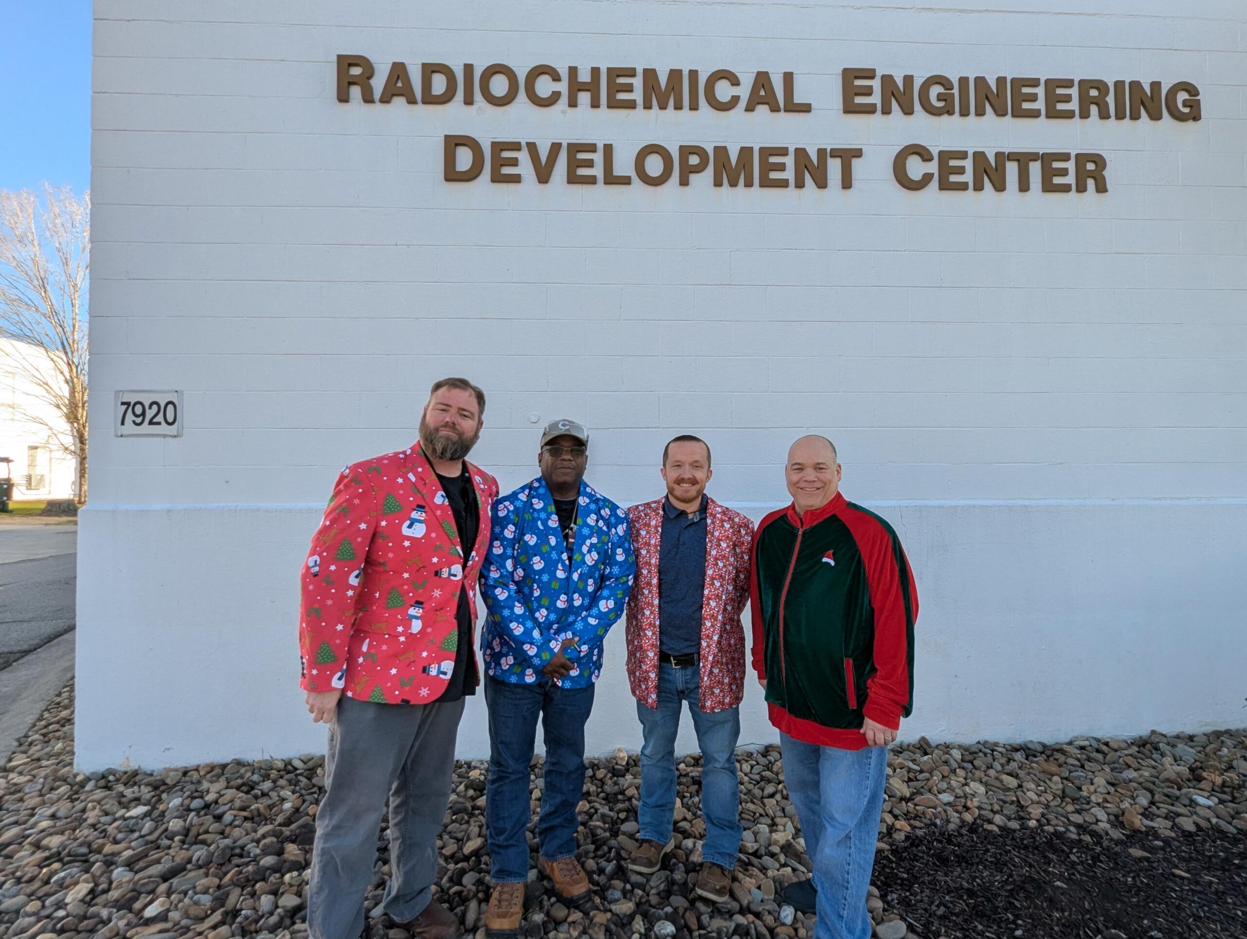 Group in Christmas clothes stands outside REDC