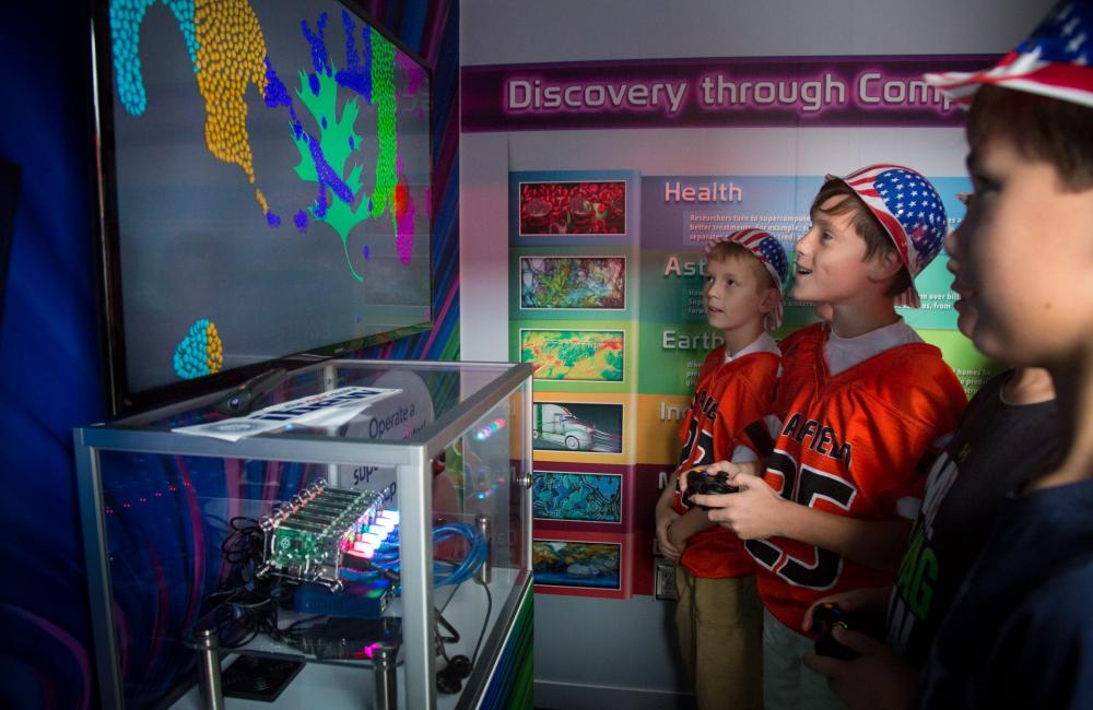 HPC Operations - outreach - kids looking at a digital presentation