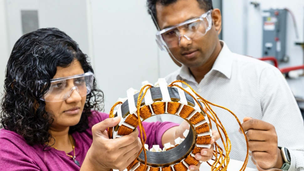 Two scientists in safety googles engage in electric drives research.
