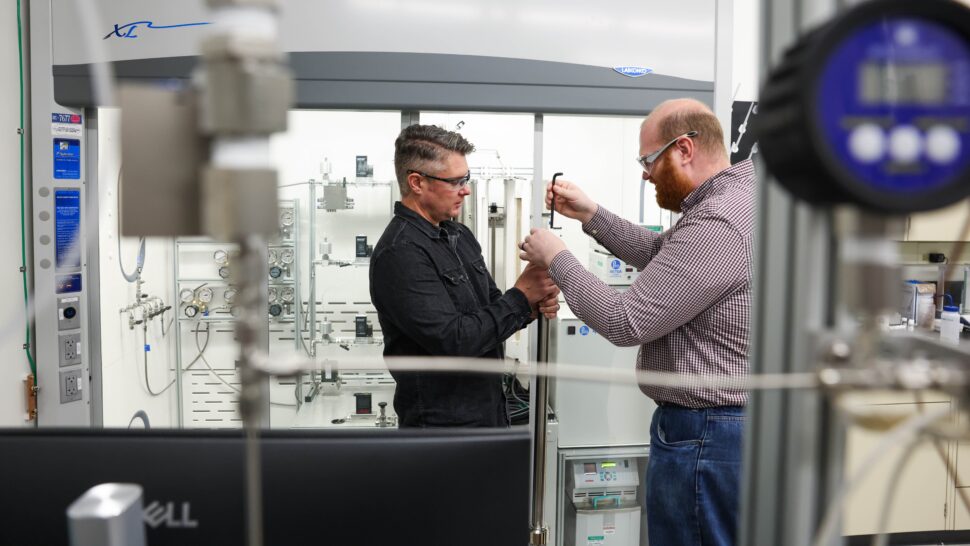Two scientist work together in a lab setting supporting the chemical process scale-up group.