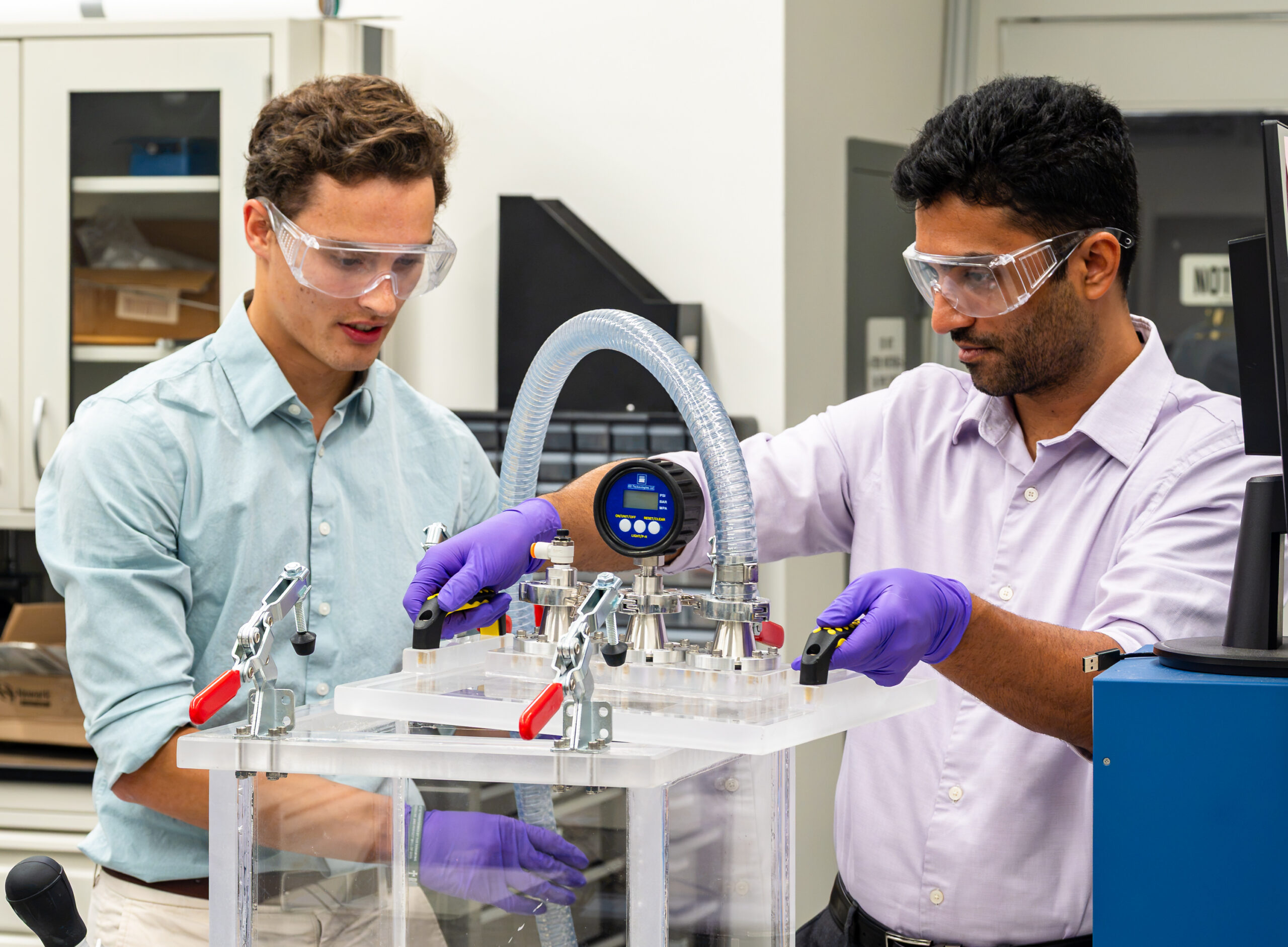 Yadukrishnan Sasikumar and Jackson Flenniken work together on spent fuel canister research in a laboratory.