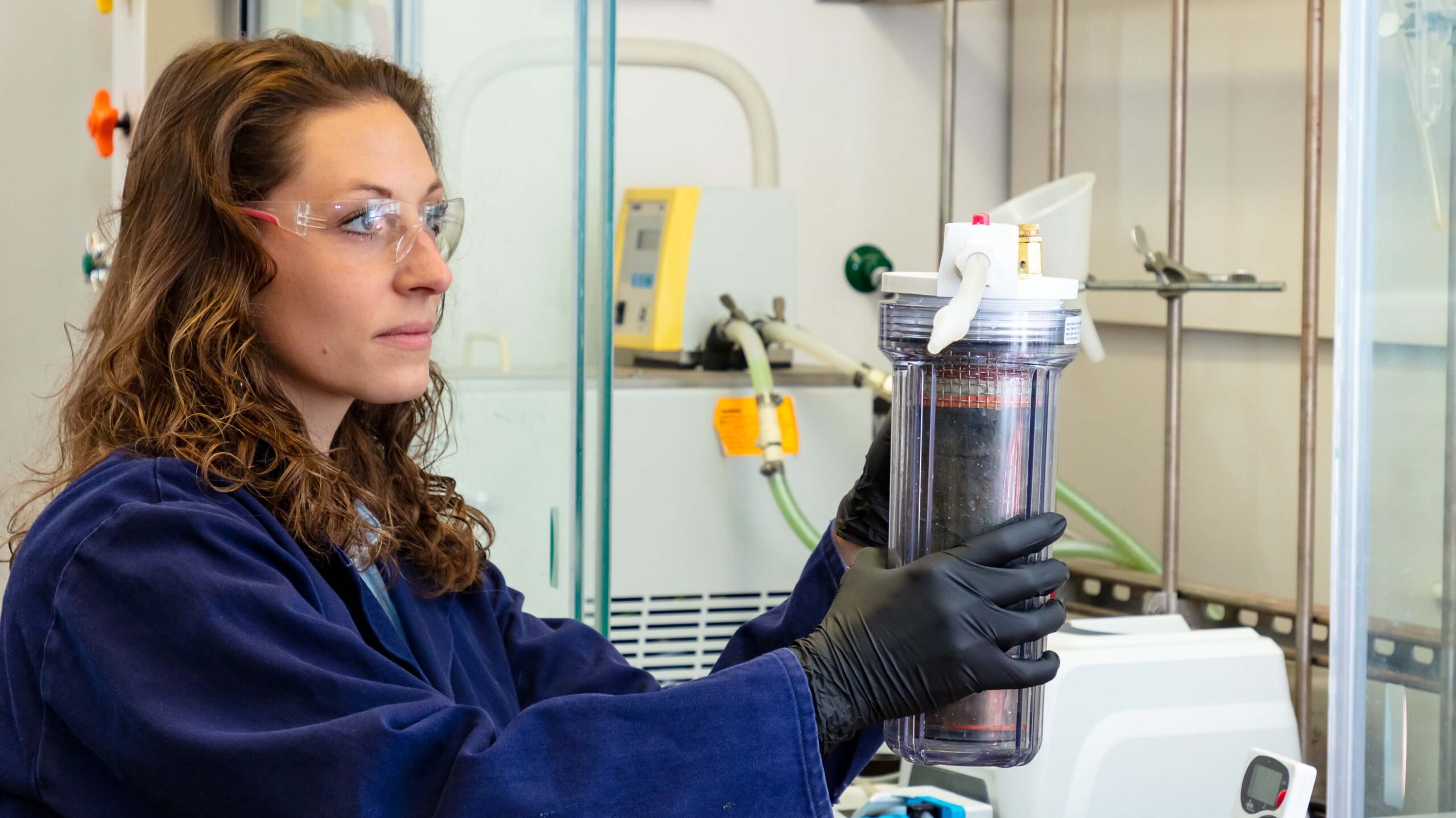 Megan O'Connor holds a canister in a laboratory. 