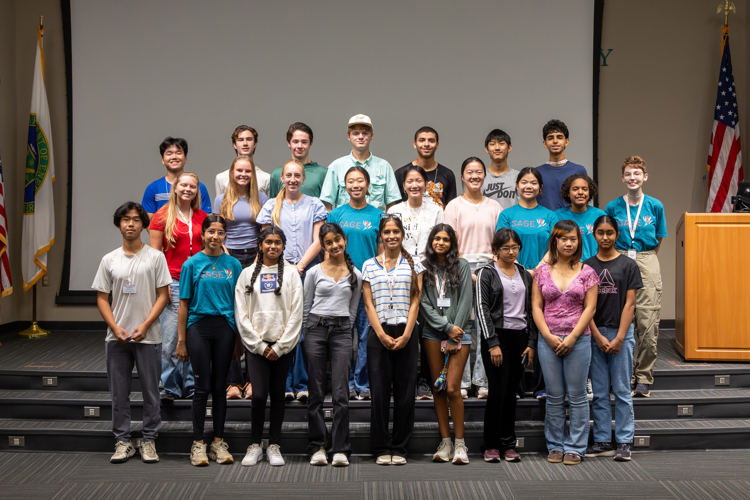 High school students participating in SAGE Camp pose together on the auditorium stage for a group photo following the Supporting Research Career Panel.