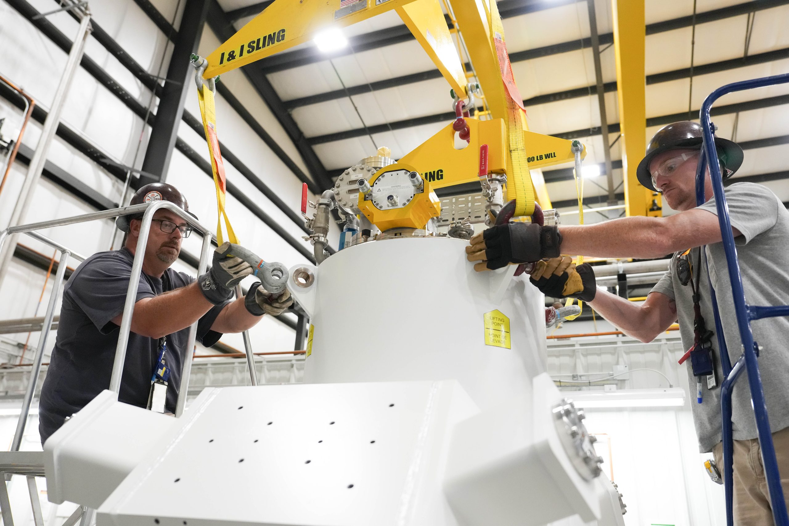 Matt Dessel oversees the placement of a large cylindrical superconducting magnet at ORNL’s Material Plasma Exposure Experiment facility.