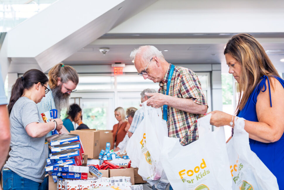 ORNL employees pack food for Second Harvest Food Bank during an ORNL Gives volunteer event in the lobby of Building 4100.