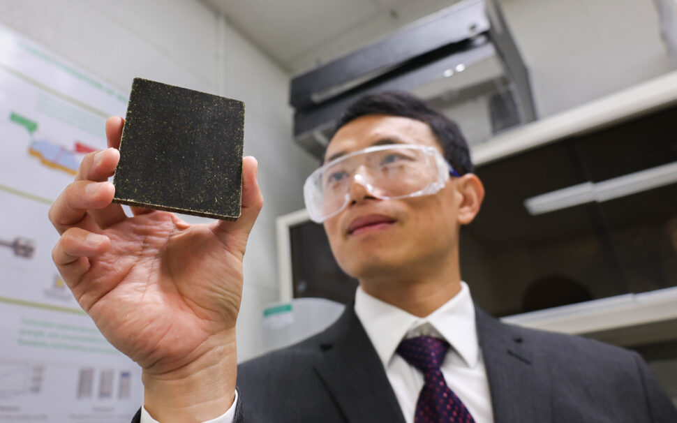 Andy Zhao holds up a piece of algae composite.
