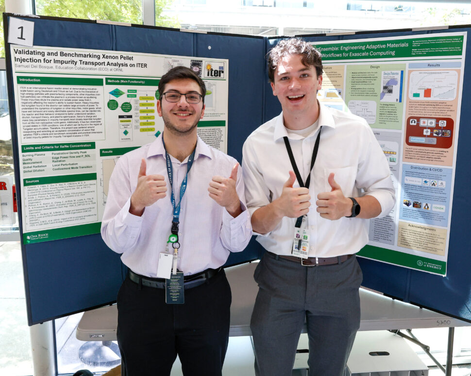 Summer student interns stand beside research posters and discuss their projects with attendees during the Summer Student Poster Session in Building 5700 at ORNL.