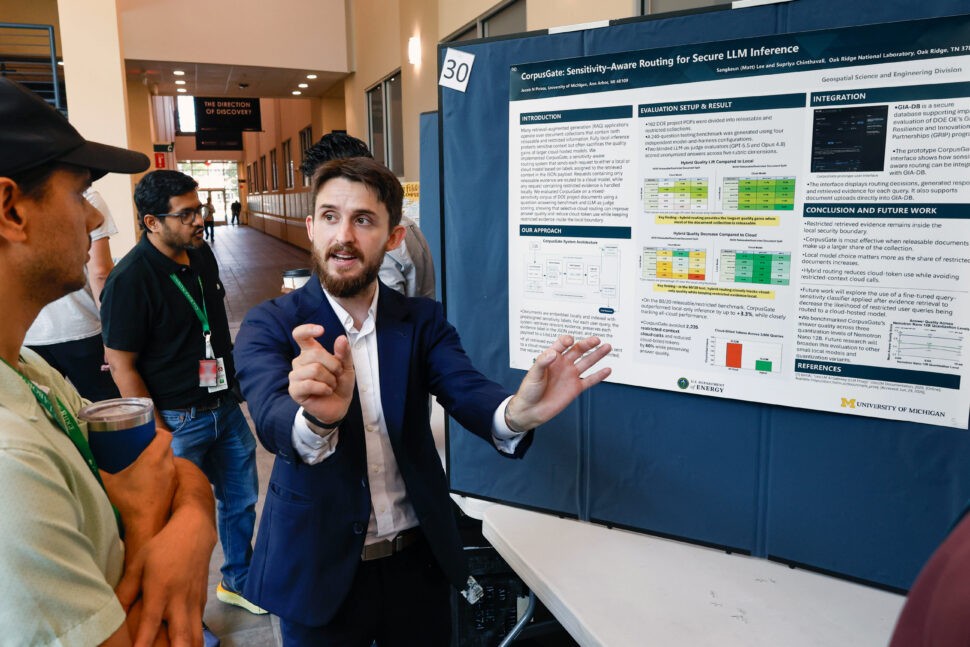 Summer interns stand beside research posters and discuss their projects with attendees during the Summer Student Poster Session in Building 5700 at ORNL.