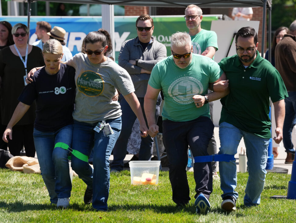 Employees gather on the Quad at Oak Ridge National Laboratory during the 2026 ORNL Gives kickoff event, visiting nonprofit booths, playing field day games, listening to live music and interacting with puppies during the annual employee-led community giving campaign.