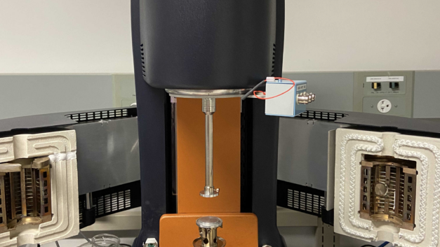 A tall, skinny black piece of equipment with a metal probe