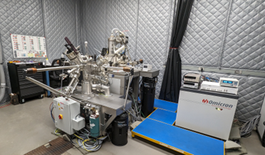 in an aluminum-shielded room, a printer-like box sits next to a comples instrument with multiple protrusions