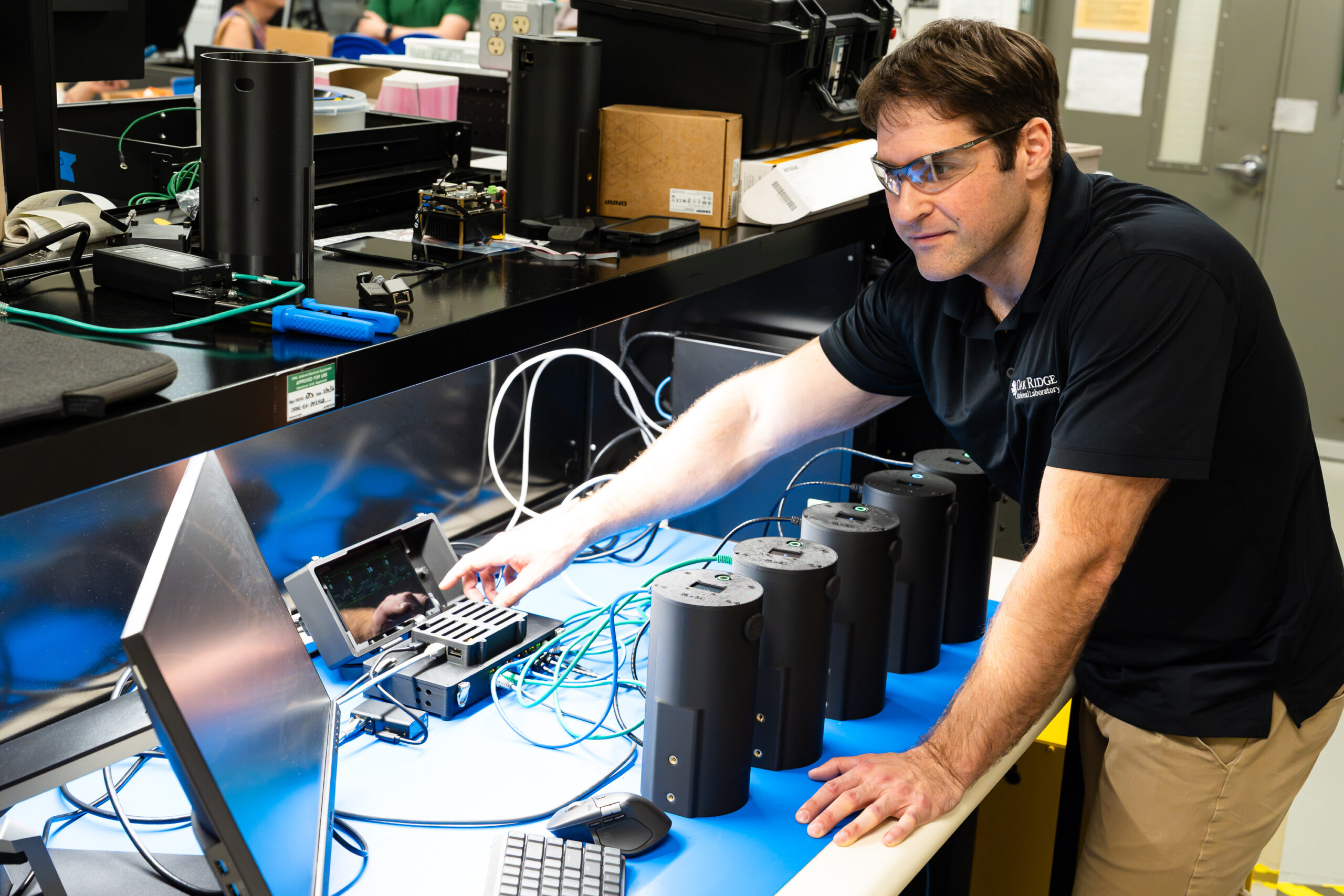 Researcher operates a testing setup with several cylindrical monitoring devices.