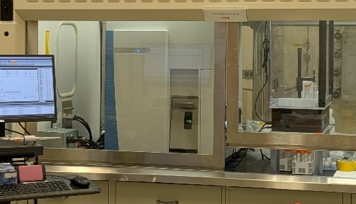 A monitor sits next to an enclosed hood workspace