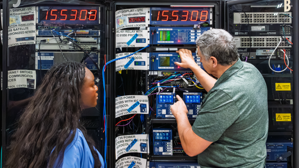 Emilio Piesciorovsky of ORNL speaks with GridForge founder and CEO Worlasie Djameh at the Hardin Valley Campus Grid-C facility.